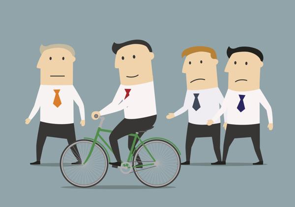 Businessman on cycle going ahead of other standing businessmen