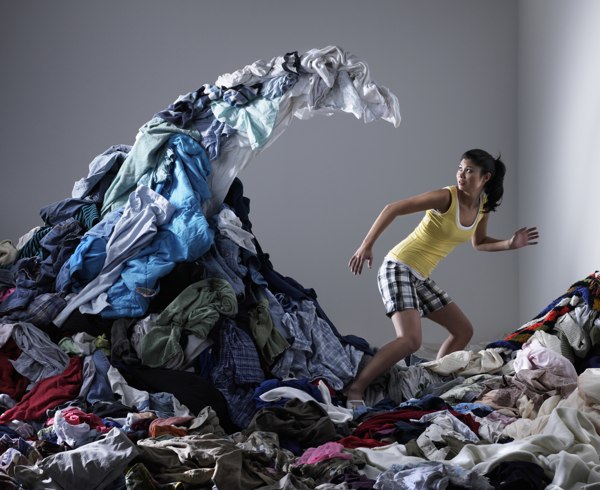 Woman running from a wave of laundry