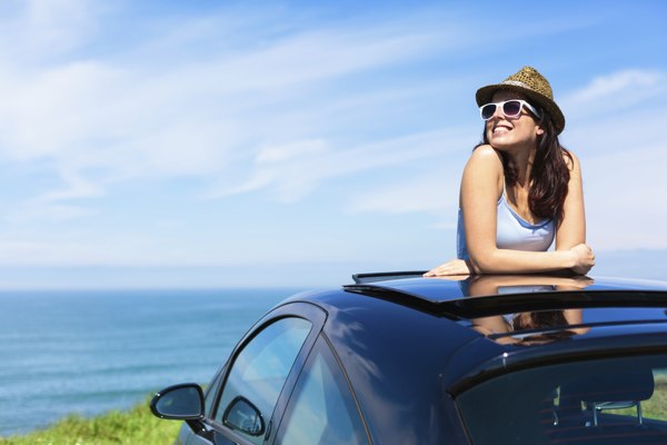 Woman leaning out the sunroof of car
