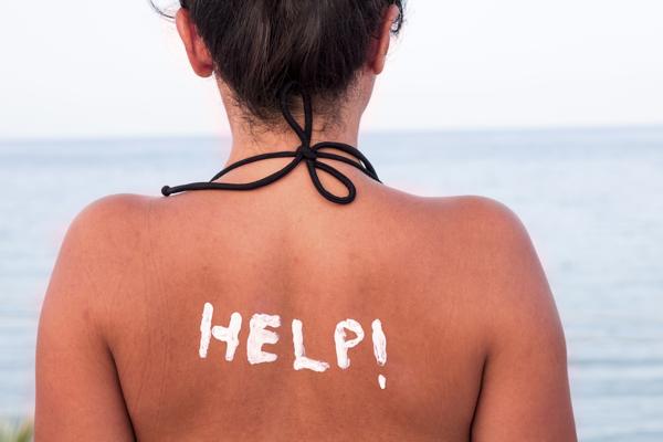 Help written with Sun Cream on a Woman's Shoulder