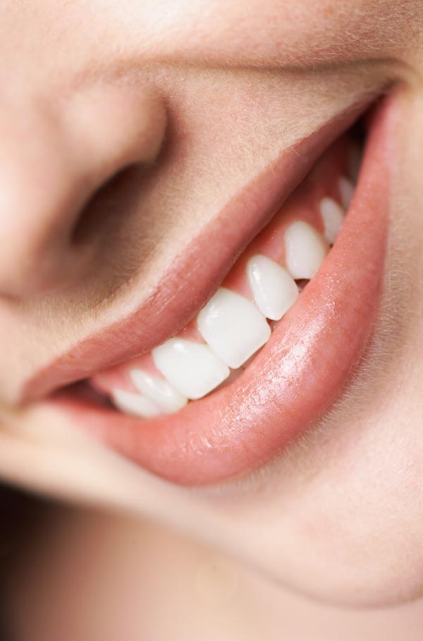 Extreme close up of a young caucasian girls pearly white teeth as she smiles