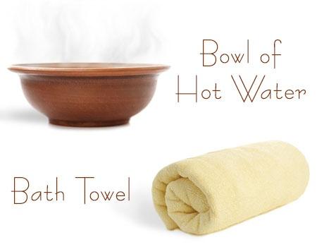 Rolled up yellow beach towel and hot water