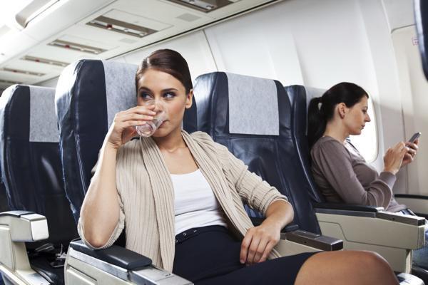 Woman drinking water in airplane