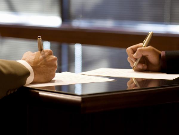 Businessmen signing documents