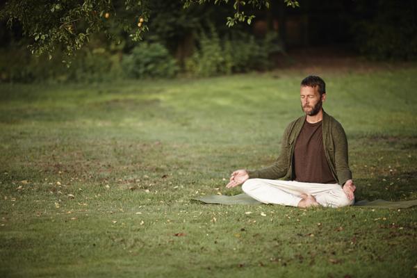 man meditating in the woods