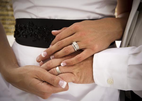 A newly married couple showing their wedding rings